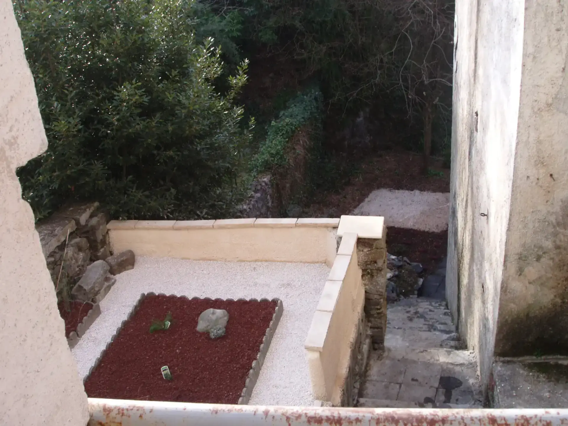 Petit jardin minéral en gravier blanc et paillage rouge